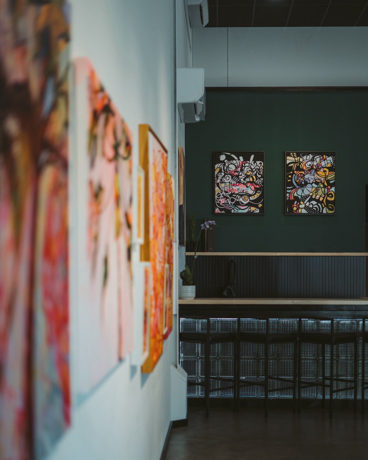 King's Tide Studio in Lāhainā, Maui — gallery wall of paintings beside the bar and event seating